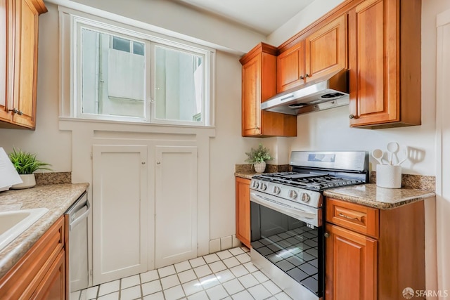 kitchen with light stone counters, stainless steel appliances, and light tile patterned flooring