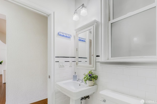 bathroom featuring tile walls and toilet