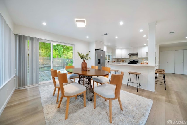 dining room featuring light hardwood / wood-style flooring and decorative columns