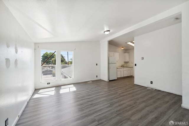 unfurnished living room with dark wood-type flooring and lofted ceiling