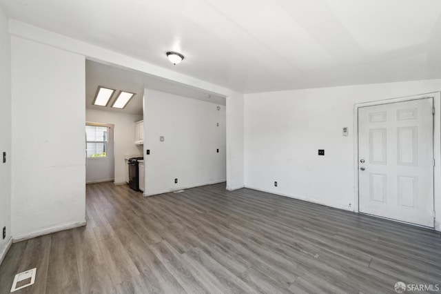 unfurnished living room featuring hardwood / wood-style flooring and lofted ceiling