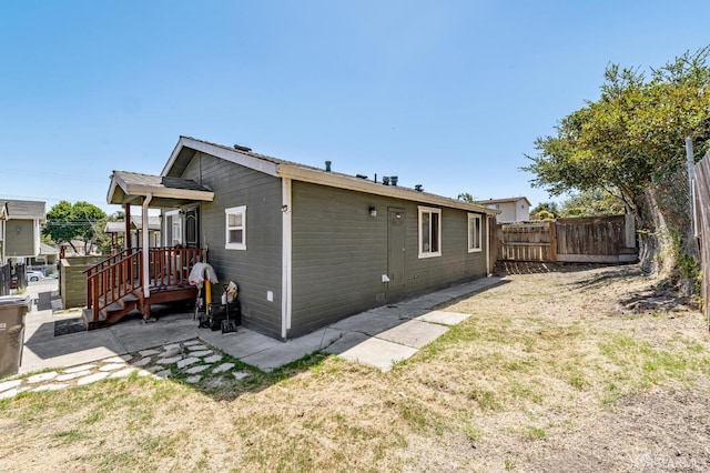 view of property exterior featuring a lawn and a patio area