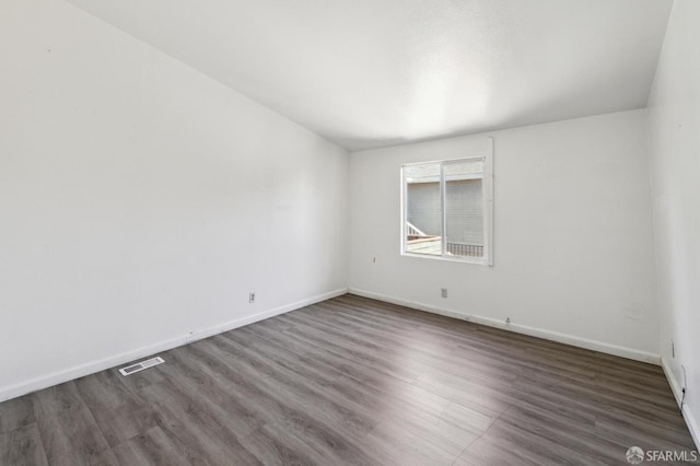 unfurnished room with dark hardwood / wood-style flooring