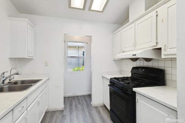 kitchen featuring white cabinets, tasteful backsplash, sink, black range with gas cooktop, and light wood-type flooring