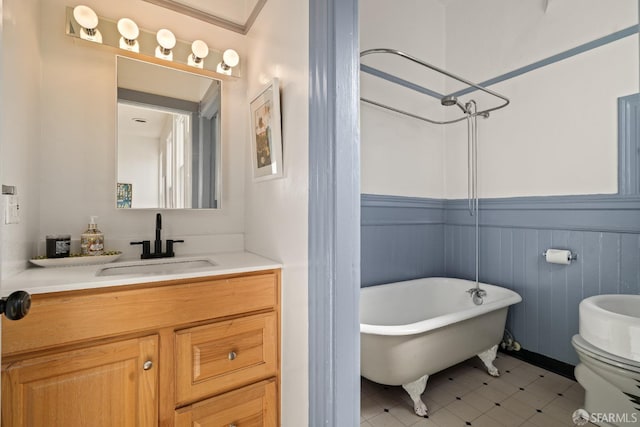 bathroom with toilet, a freestanding bath, and vanity