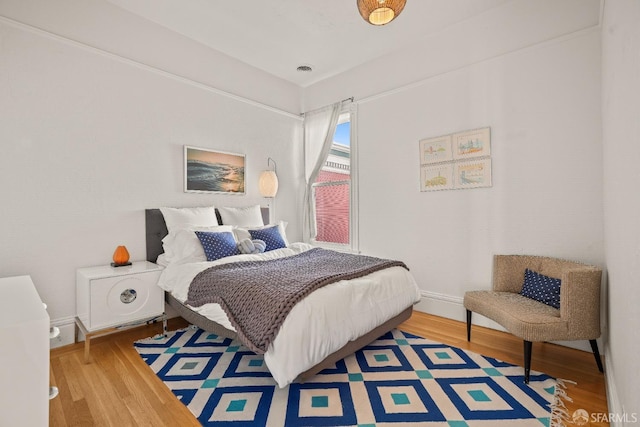 bedroom with visible vents and wood finished floors