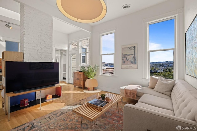 living area featuring visible vents and wood finished floors