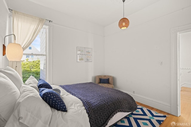 bedroom featuring baseboards and light wood finished floors