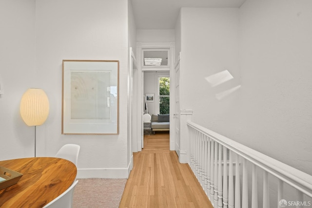 corridor with light wood-style flooring and baseboards