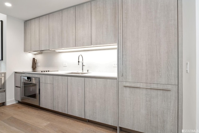 201 Folsom St Unit 2A, San Francisco, CA 94105 - kitchen with a sink, oven, modern cabinets, light wood-style floors, and light countertops