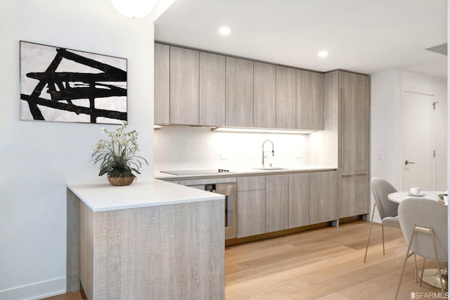 201 Folsom St Unit 2A, San Francisco, CA 94105 - kitchen with modern cabinets, a sink, light wood-type flooring, light brown cabinetry, and black electric cooktop