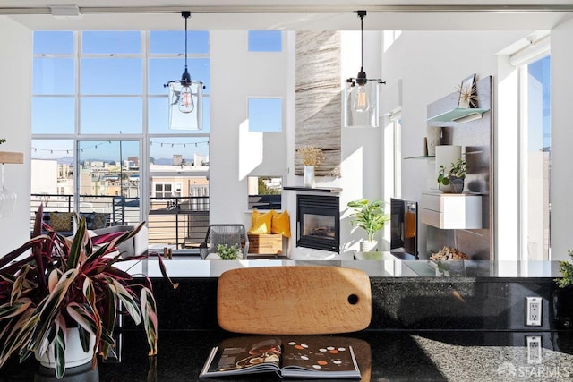 living room with a multi sided fireplace, a towering ceiling, and a wealth of natural light