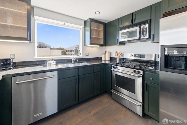 kitchen featuring dark wood-type flooring, green cabinets, appliances with stainless steel finishes, and sink