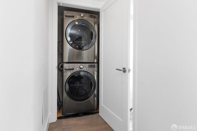 washroom with stacked washer and dryer and dark hardwood / wood-style flooring