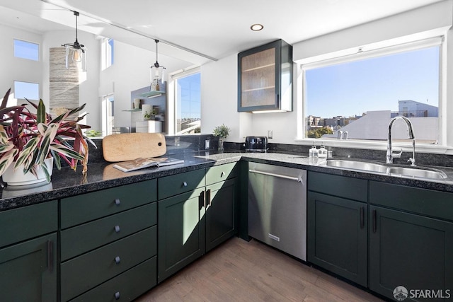 kitchen with sink, dishwasher, dark hardwood / wood-style floors, decorative light fixtures, and dark stone counters