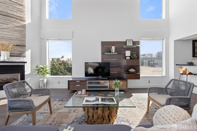 living room with dark hardwood / wood-style floors and a towering ceiling