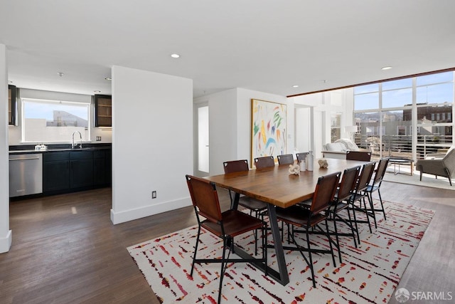 dining space featuring dark wood-type flooring, a wall of windows, and sink