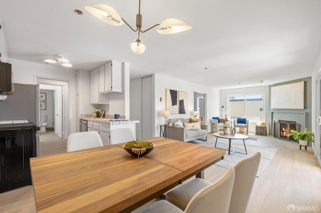 389 Belmont St Unit 306, Oakland, CA 94610 - dining area featuring light wood-type flooring and a lit fireplace