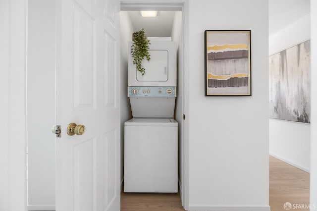 389 Belmont St Unit 306, Oakland, CA 94610 - laundry room featuring stacked washing machine and dryer and wood finished floors