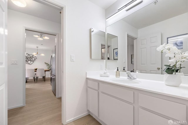 389 Belmont St Unit 306, Oakland, CA 94610 - bathroom featuring vanity, wood finished floors, and a chandelier