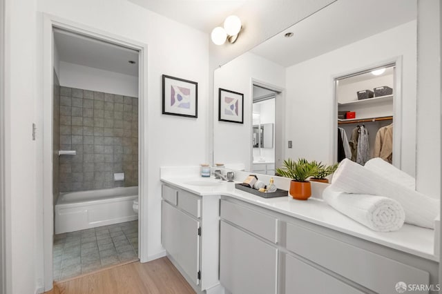 389 Belmont St Unit 306, Oakland, CA 94610 - bathroom featuring vanity, wood finished floors, a walk in closet, and shower / bathtub combination