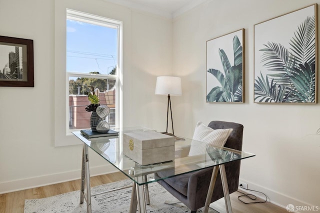 office space with baseboards, ornamental molding, and wood finished floors