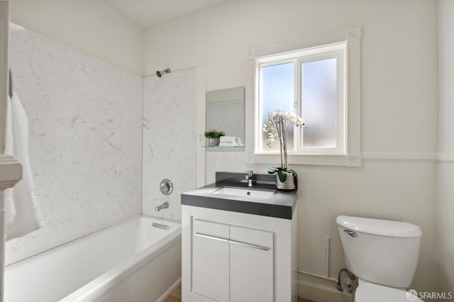 full bath featuring shower / bathtub combination, toilet, wainscoting, and vanity