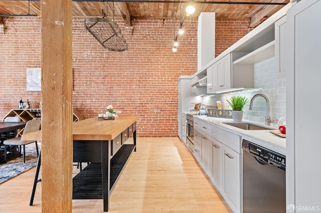 355 Bryant St Unit 411, San Francisco, CA 94107 - kitchen featuring stainless steel appliances, brick wall, open shelves, light wood-style floors, and wooden ceiling