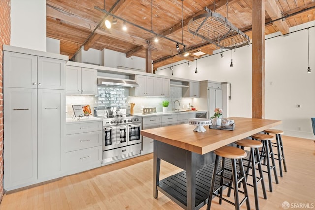 355 Bryant St Unit 411, San Francisco, CA 94107 - kitchen with double oven range, a wood ceiling with exposed beams, rail lighting, decorative backsplash, and light wood-type flooring