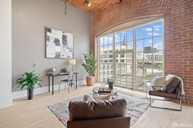355 Bryant St Unit 411, San Francisco, CA 94107 - living room with a towering ceiling, brick wall, wooden ceiling, and wood finished floors