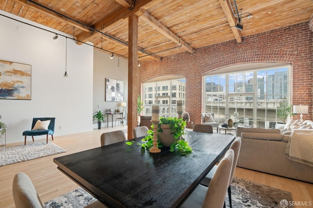 355 Bryant St Unit 411, San Francisco, CA 94107 - dining space featuring track lighting, brick wall, a wooden ceiling with exposed beams, wood finished floors, and a view of city