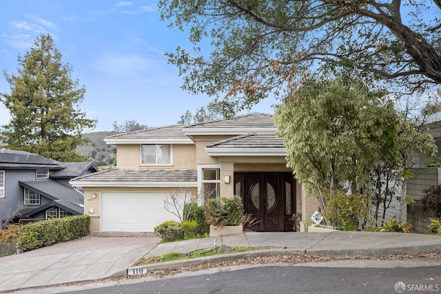 110 Sheridan Rd, Oakland, CA 94618 - view of front of house featuring stucco siding, driveway, an attached garage, and a tiled roof