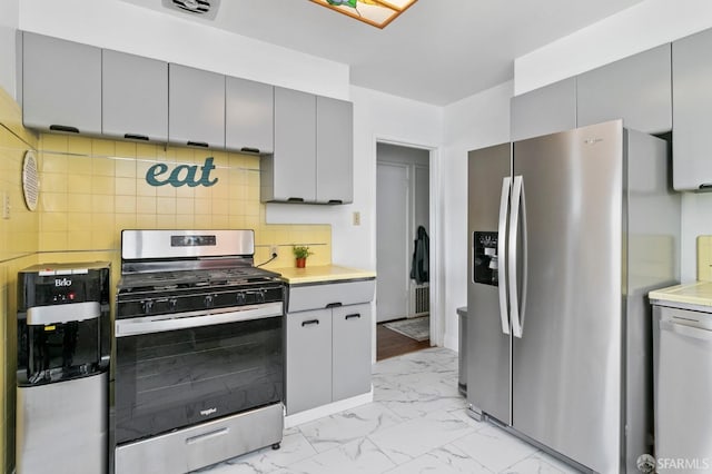 kitchen with stainless steel appliances, tasteful backsplash, and gray cabinets