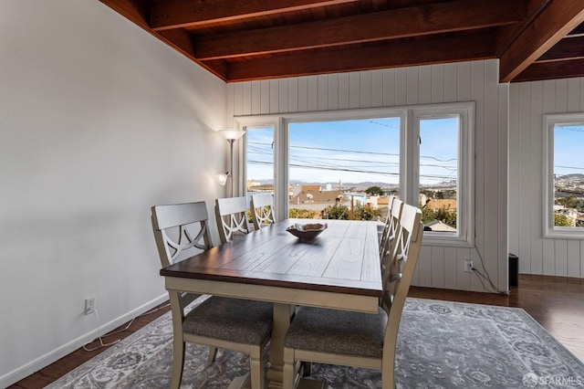 dining space featuring dark wood-type flooring, a wealth of natural light, and beam ceiling