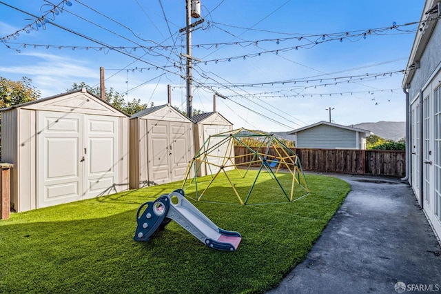 view of play area with a shed and a yard