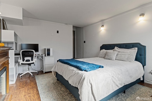 bedroom with ornamental molding and dark hardwood / wood-style floors