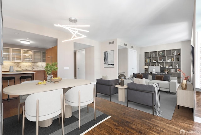 dining space with dark hardwood / wood-style floors and a chandelier