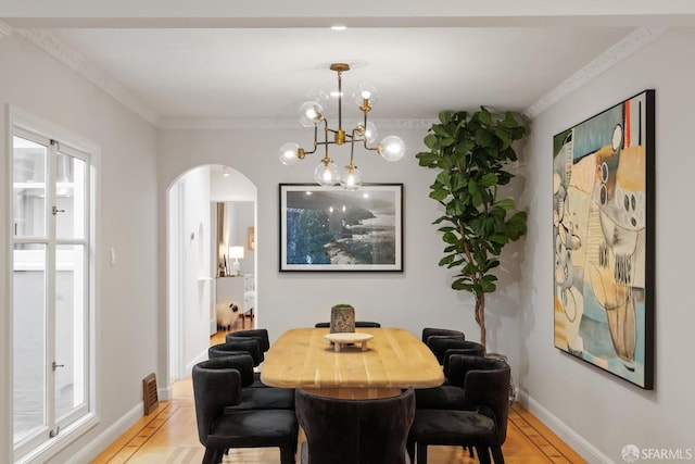 dining room with ornamental molding, a chandelier, and light wood-type flooring