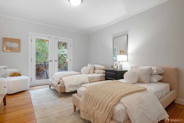 bedroom with french doors, ornamental molding, light wood-type flooring, and access to outside