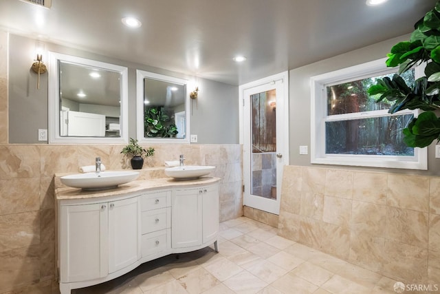 bathroom featuring vanity and tile walls