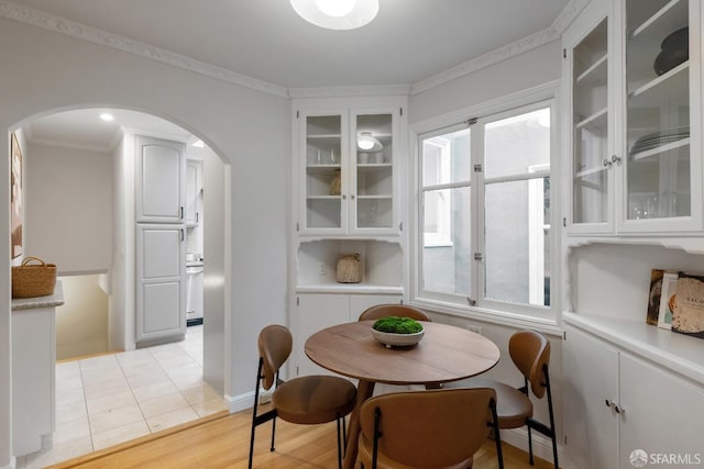 tiled dining area with crown molding and plenty of natural light