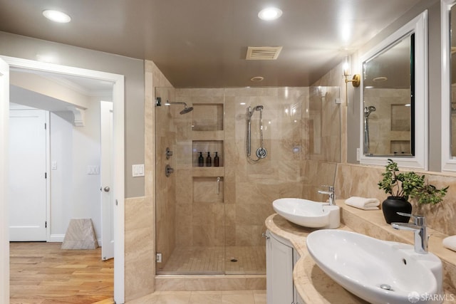 bathroom with a shower with door, vanity, and hardwood / wood-style floors