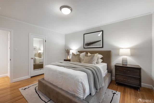 bedroom featuring ornamental molding and light hardwood / wood-style floors