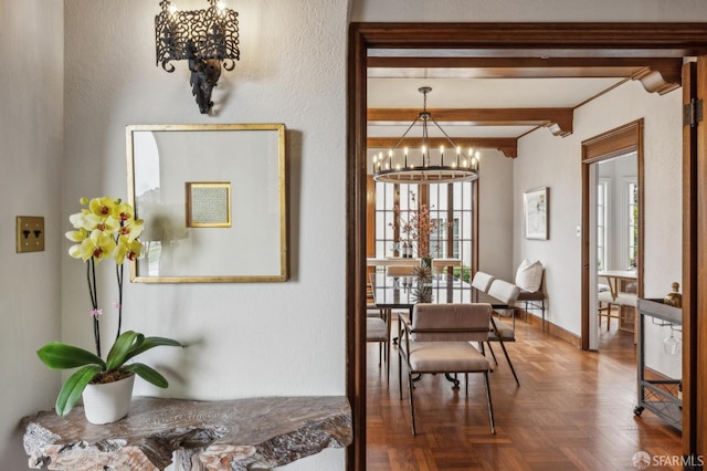 hallway featuring baseboards, an inviting chandelier, and beam ceiling