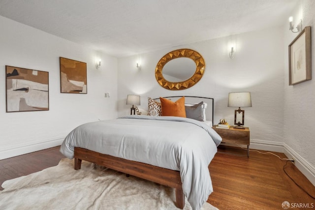 bedroom featuring baseboards and wood finished floors