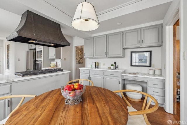 kitchen featuring custom range hood, gray cabinetry, appliances with stainless steel finishes, and wooden counters