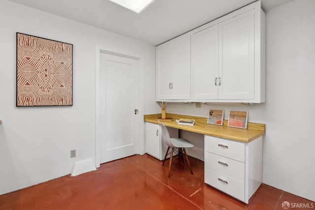 office area featuring finished concrete floors and built in desk