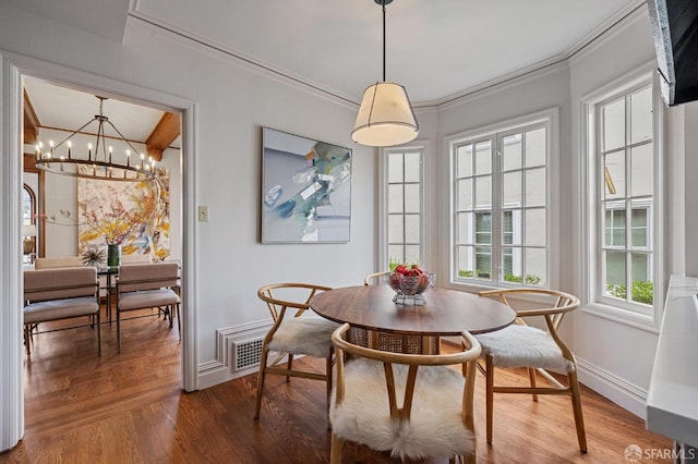 dining space with crown molding, wood finished floors, baseboards, and visible vents