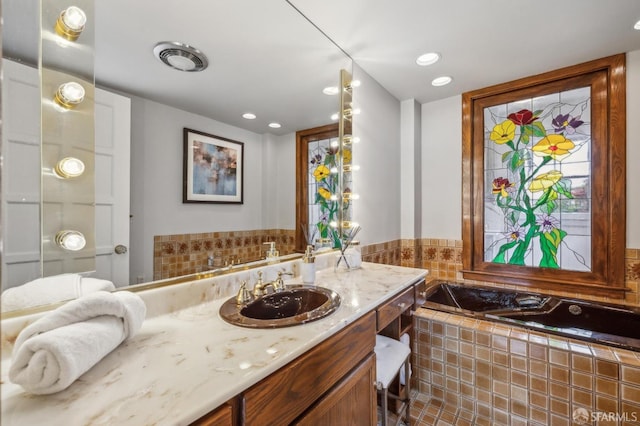 full bathroom featuring recessed lighting, vanity, visible vents, and tiled bath