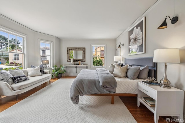 bedroom featuring multiple windows, ornamental molding, and wood finished floors